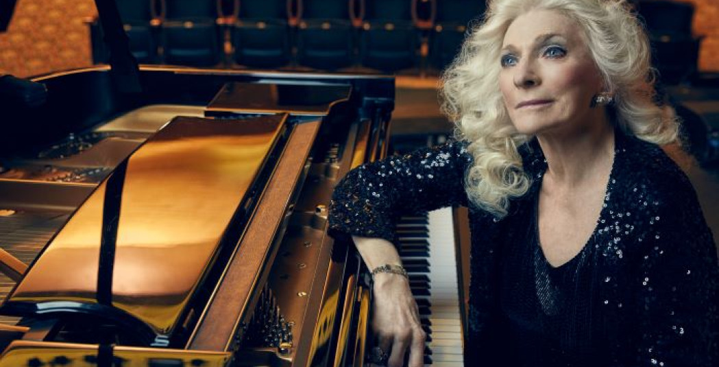 Judy Collins sitting at a piano