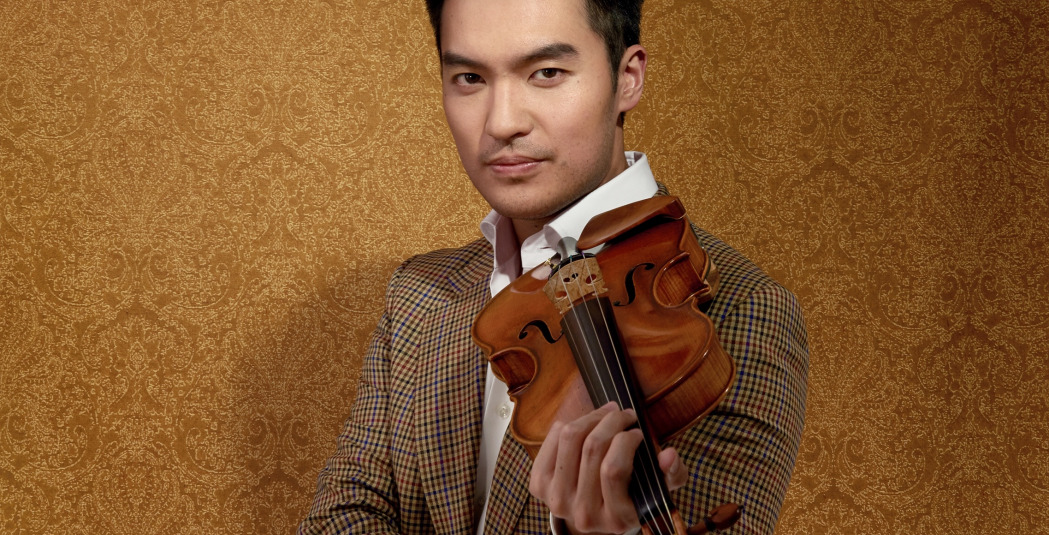 Man in brown suit standing with violin