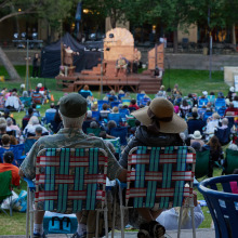 Members of the community sit on the Campus Green to enjoy performances during Summer at Soka