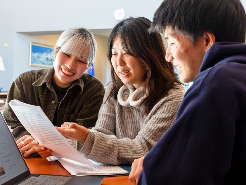 Three students reviewing work on a piece of paper