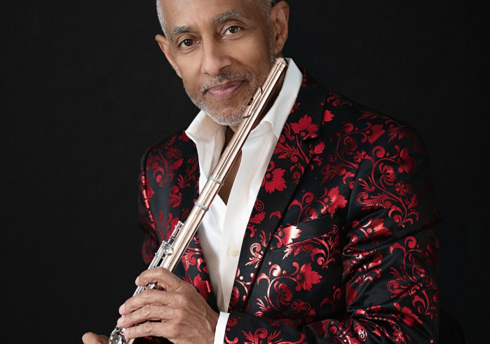 Man in a red jacket holding a flute