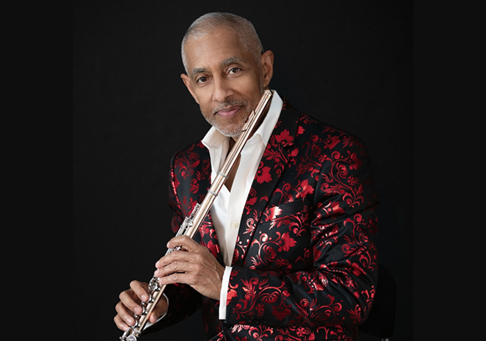 Man in a red jacket holding a flute