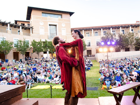 Actors hold eachother during a performance of Shakespeare by the Sea on SUA's Campus Green